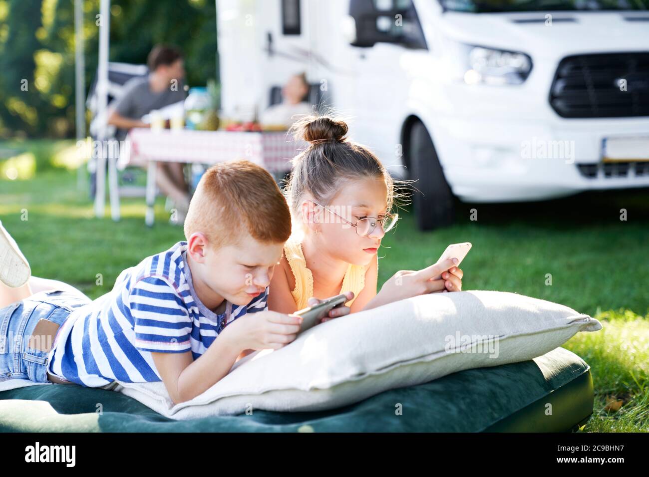 Niños con teléfono móvil en vacaciones camping Foto de stock