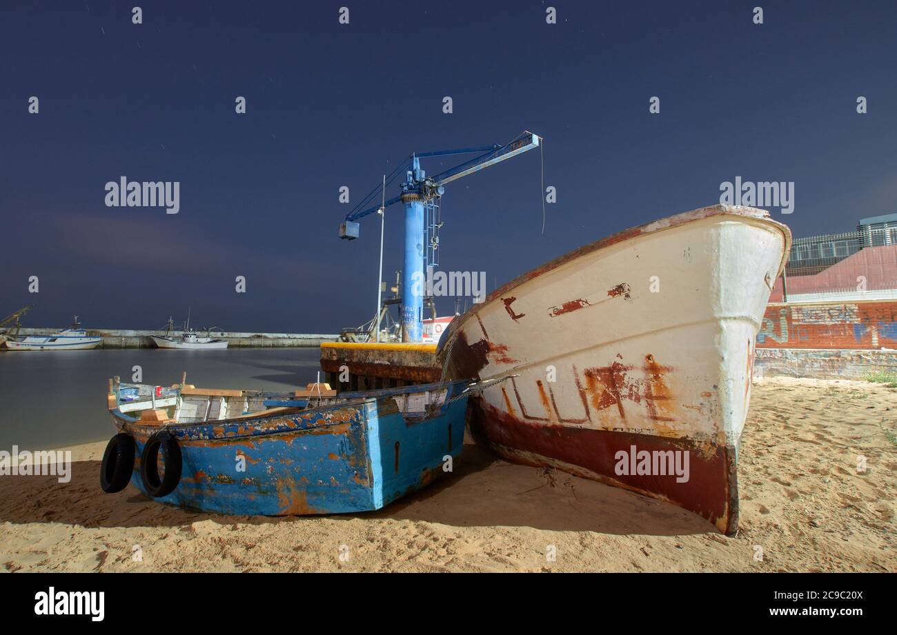 Escena nocturna de un barco de pesca en la costa de Cádiz, Andalucía, España Foto de stock
