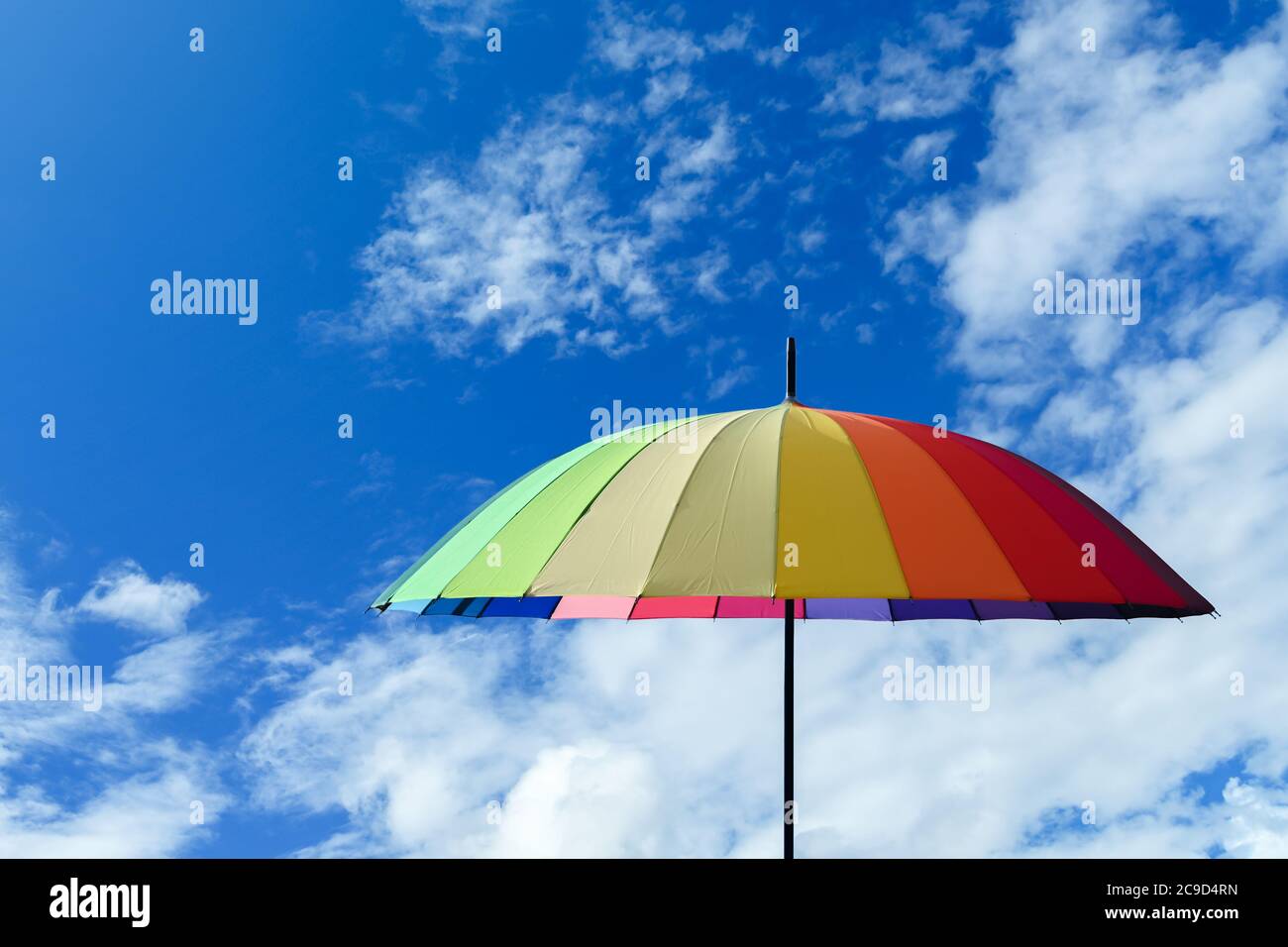 Paraguas colorido multicolor sobre fondo azul del cielo Foto de stock