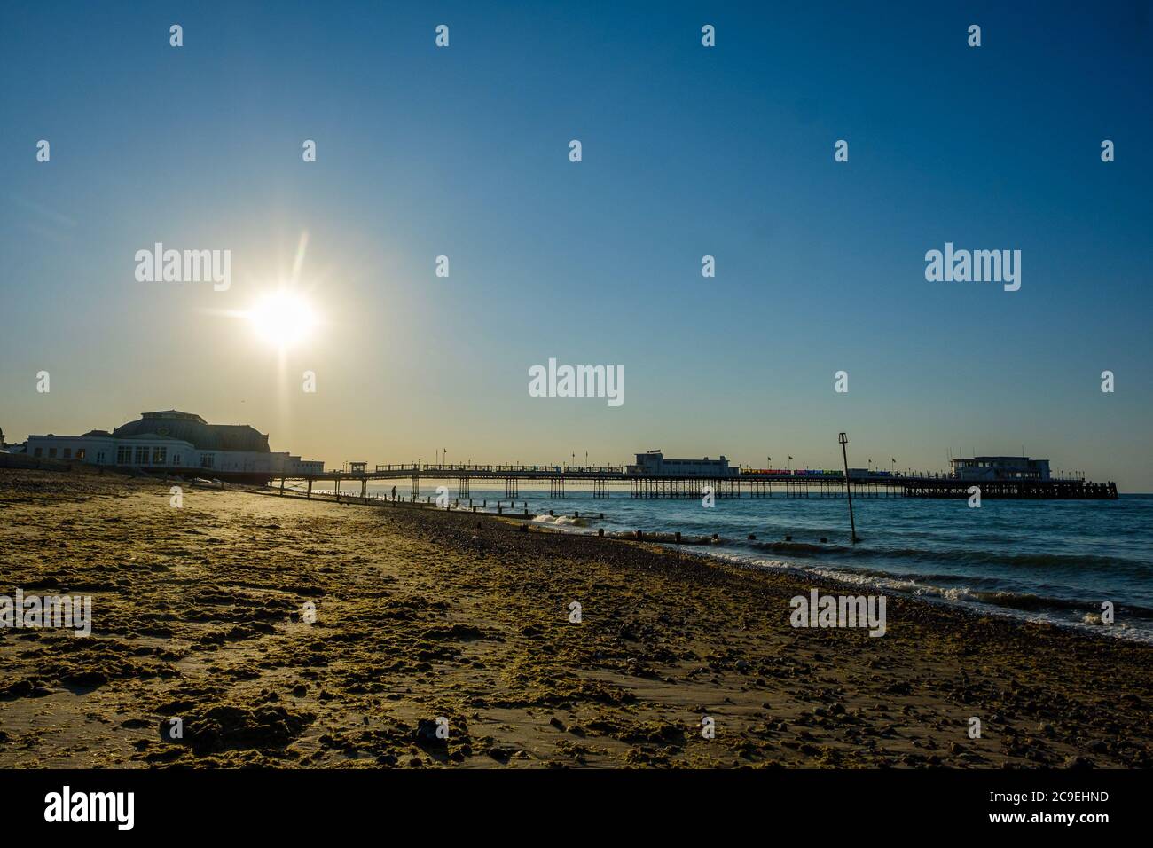 Worthing Beach, Worthing, Reino Unido. 31 de julio de 2020. El sol se eleva sobre el muelle y la rueda de observación en lo que se prevé que será uno de los días más calurosos del año. Imagen de crédito: Julie Edwards/Alamy Live News Foto de stock