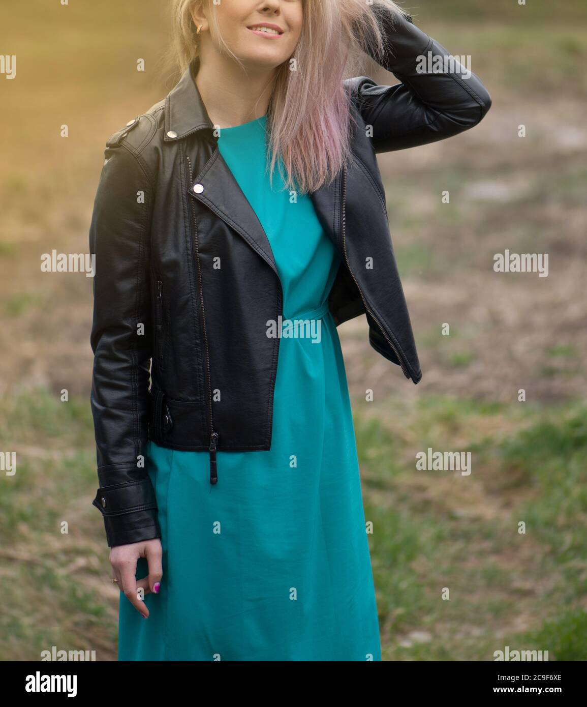 Modelo niña con un vestido de color turquesa y una chaqueta de cuero negro.  Hermosa mujer maquillaje con sombras rosadas Fotografía de stock - Alamy