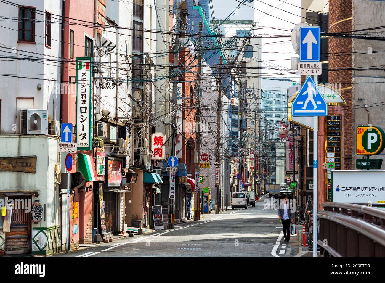 Fukuoka, Japón, mayo de 28 2019, típica calle de la ciudad con caos de cables eléctricos sobre la carretera Foto de stock