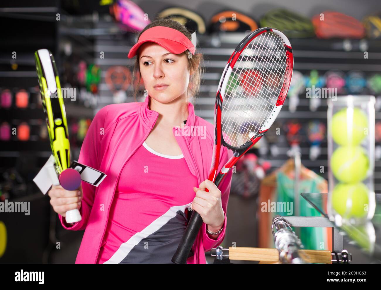 mujer en uniforme está sosteniendo una nueva para el pádel y el tenis en la tienda de Fotografía de stock - Alamy
