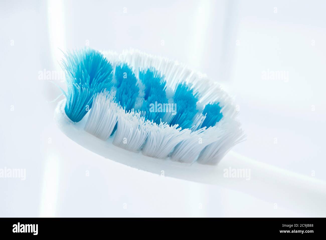 Cepillo de dientes usado sobre un fondo blanco. Foto de stock