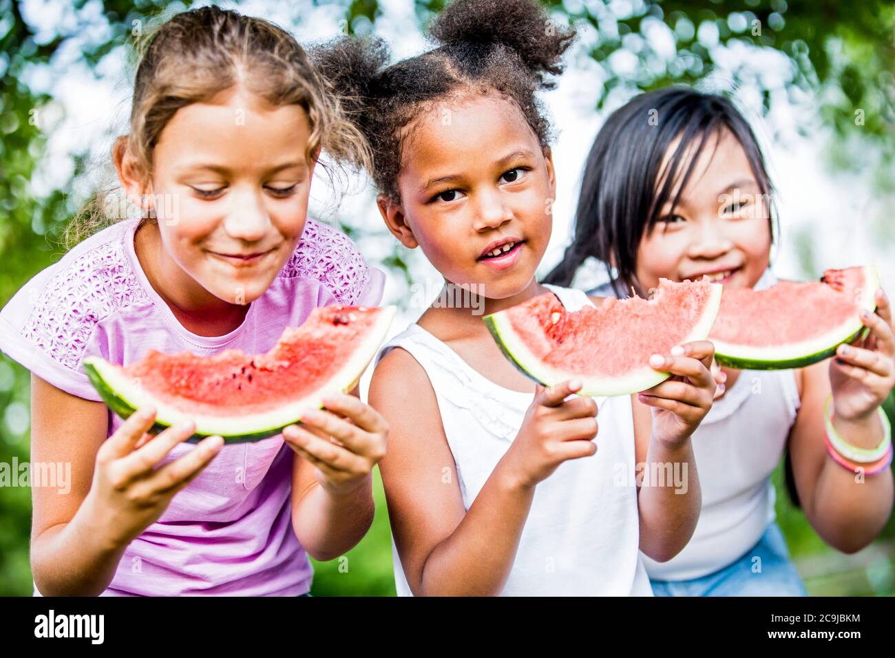 Niñas comiendo sandía en el parque. Foto de stock