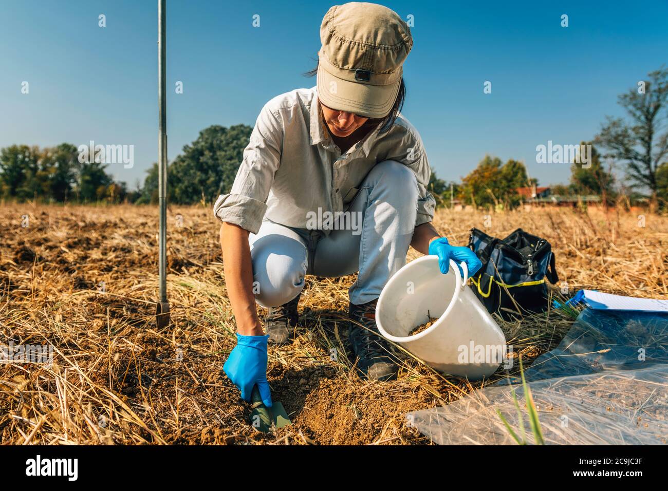 Proceso de muestreo de suelos. Mujer agrónomo tomando muestra de suelo