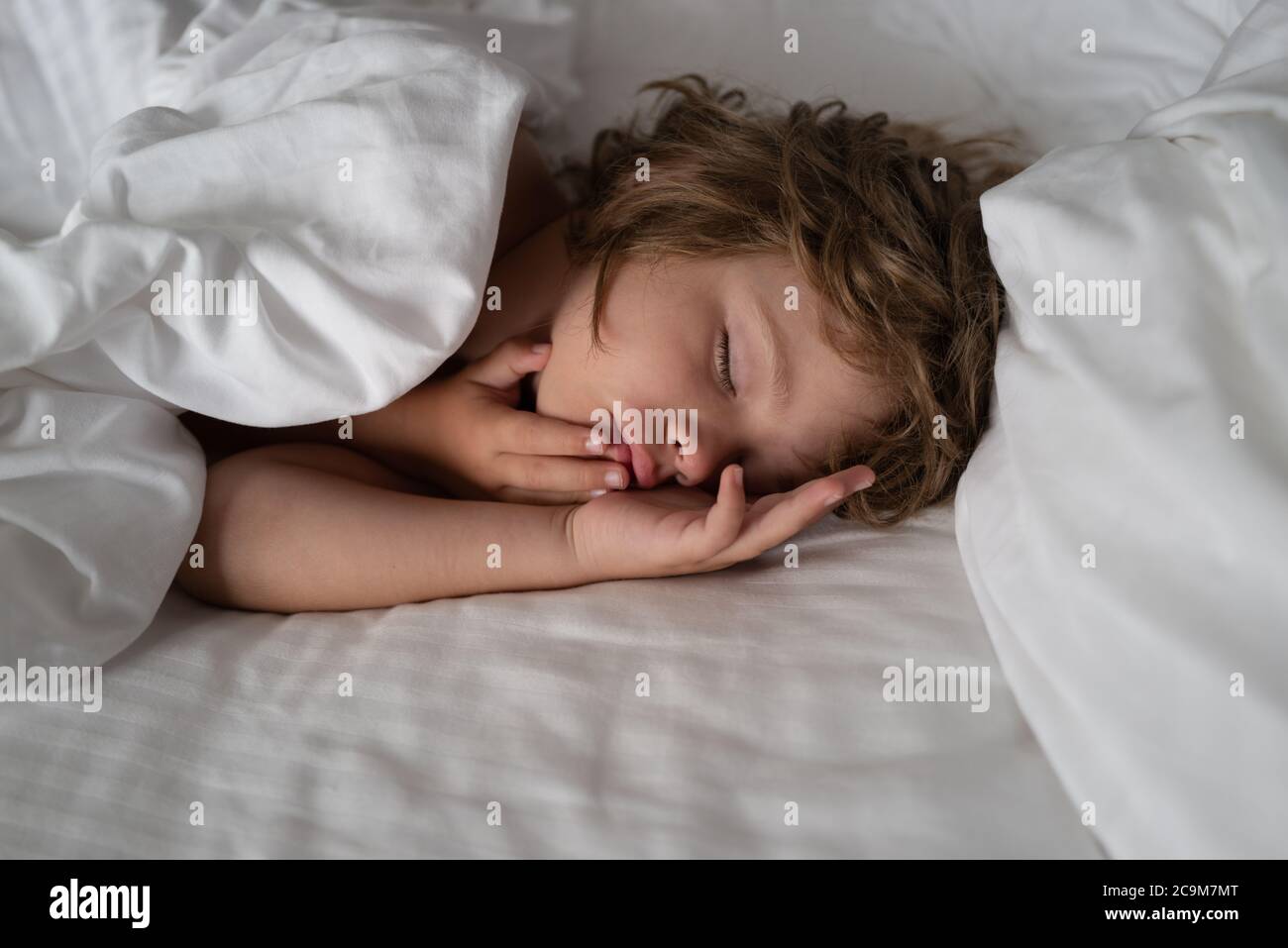 Los niños duermen en la cama. Buenas noches. Niño adorable y tranquilo  acostado sobre almohadas suaves Fotografía de stock - Alamy