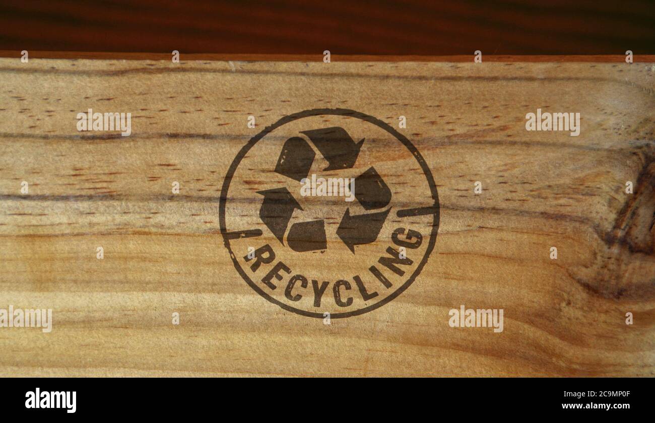 Sello de reciclaje impreso en caja de madera. Recicle el símbolo, las flechas, los materiales reciclables, la protección del medio ambiente y el concepto de tierra segura. Foto de stock