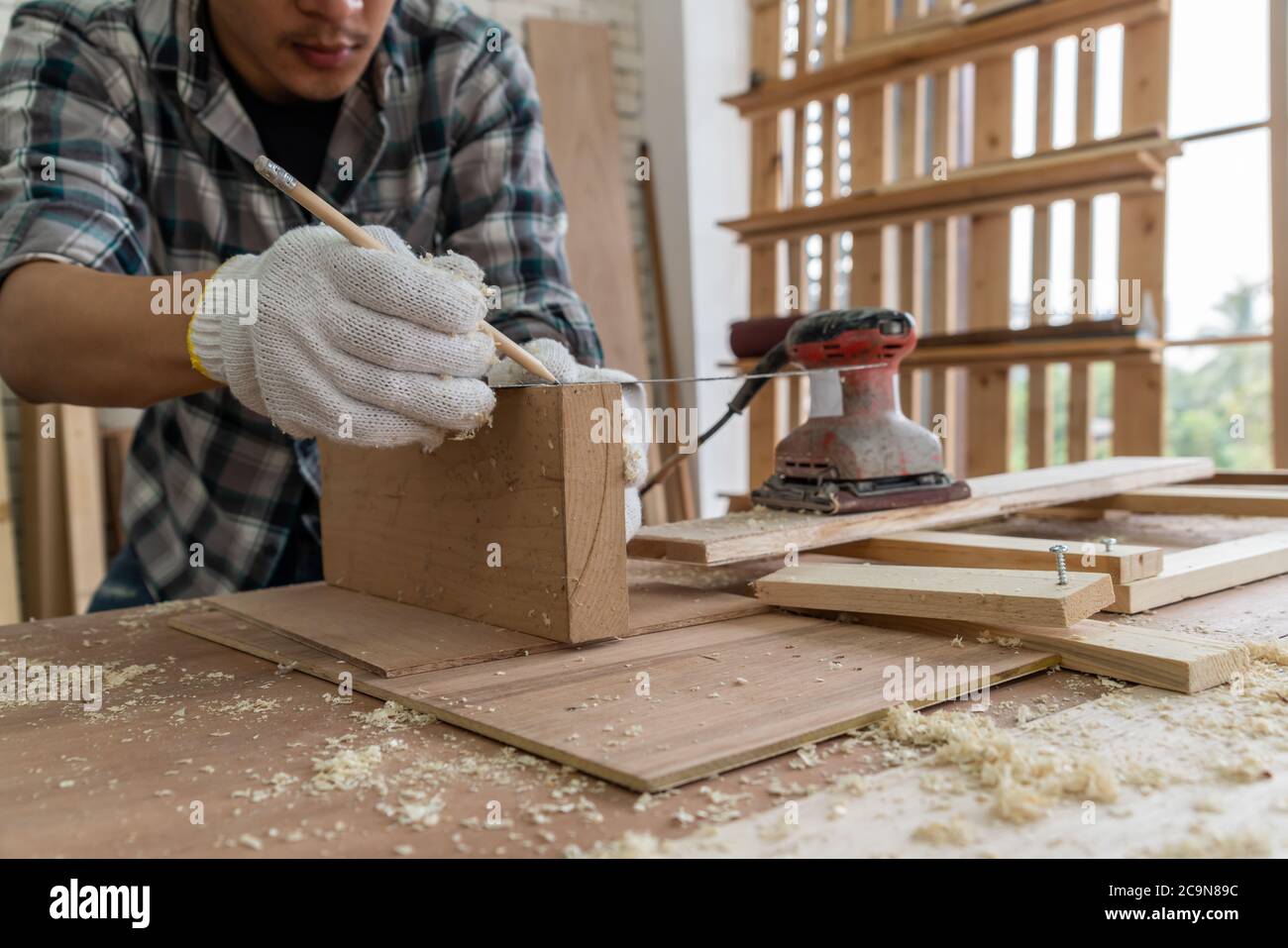 Trabajador feliz cortando madera con serrucho en el sitio Fotografía de  stock - Alamy