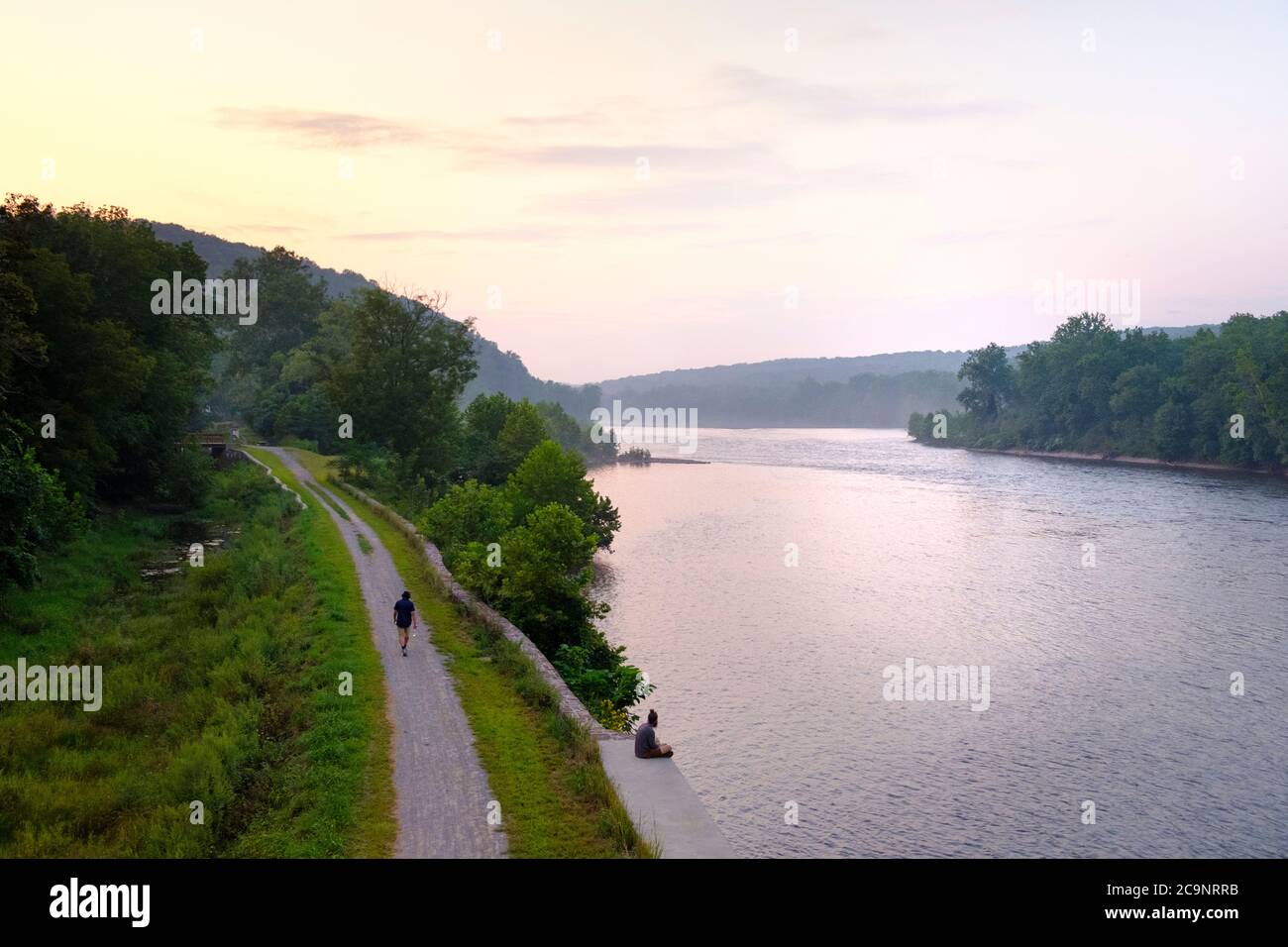 Vista desde PA a NJ sobre el río Delaware, al atardecer con sendero para bicicletas (parte del Parque Estatal del Canal de Delaware y Raritan), Nueva Jersey, Estados Unidos Foto de stock