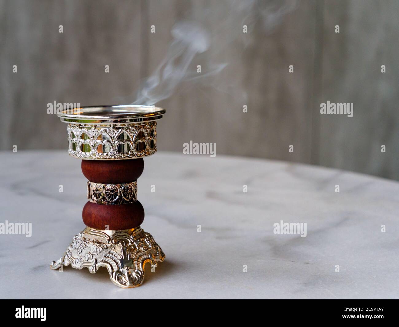 Quemador de incienso de Bakhoor Arábigo adornado / incensario que emite humo blanco. Con espacio de copia Foto de stock