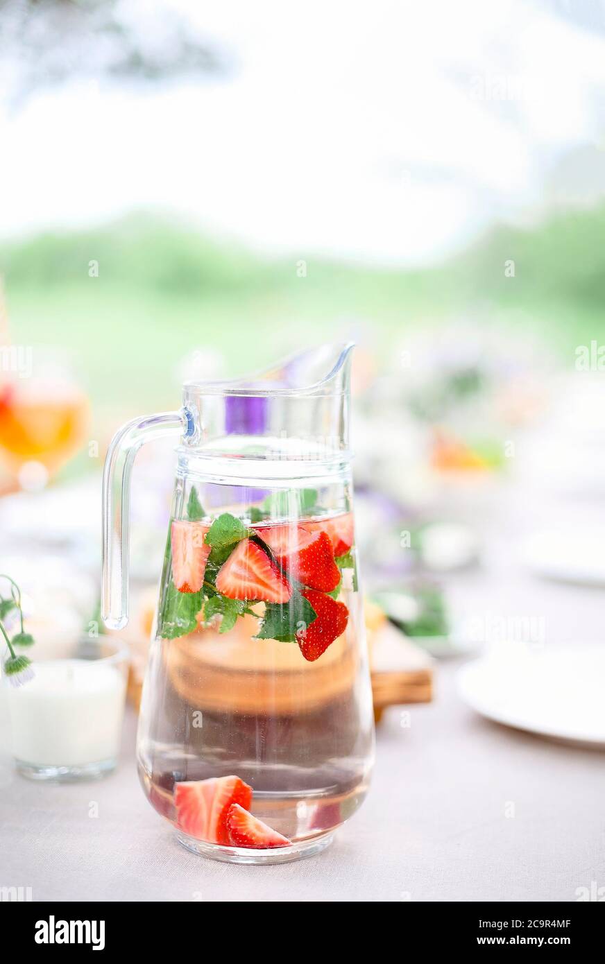 Jarra de cristal de agua fresca con menta y fresas colocada en la mesa en  la terraza para el desayuno por la mañana Fotografía de stock - Alamy