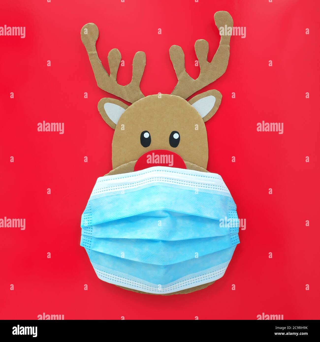 Corte de cartón de Rudolph los renos de nariz roja usando una máscara  facial. Covid durante la temporada de Navidad concepto Fotografía de stock  - Alamy