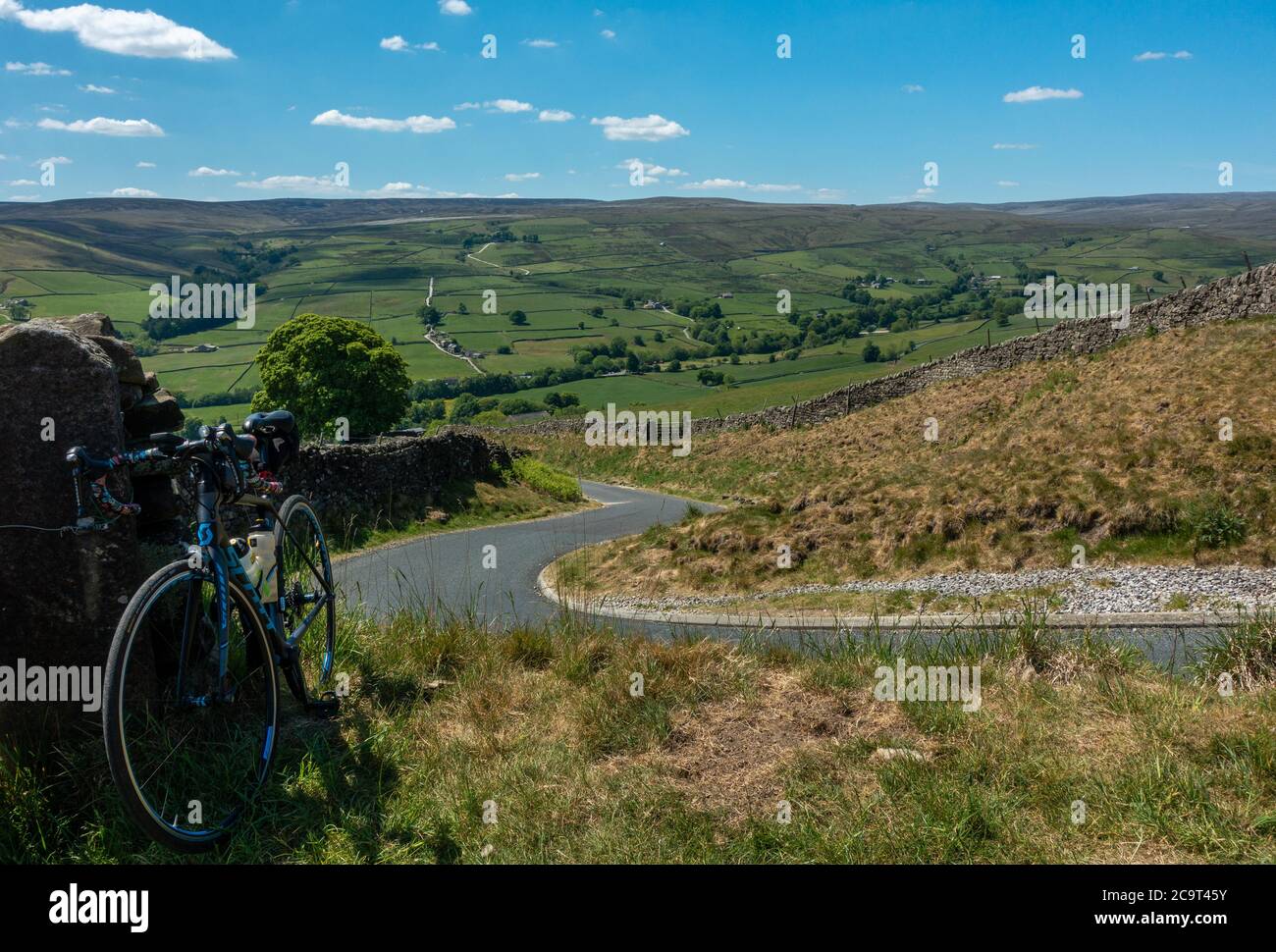 El ciclista se detuvo en el camino hacia abajo atrapando a Hill en Nidderdale y a través de la aldea de Middlesmoor, North Yorkshire, Inglaterra, reino unido Foto de stock