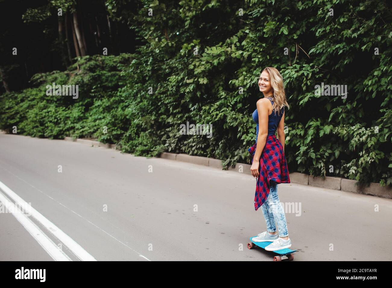 hermoso rubio patina en un parque de la ciudad Foto de stock