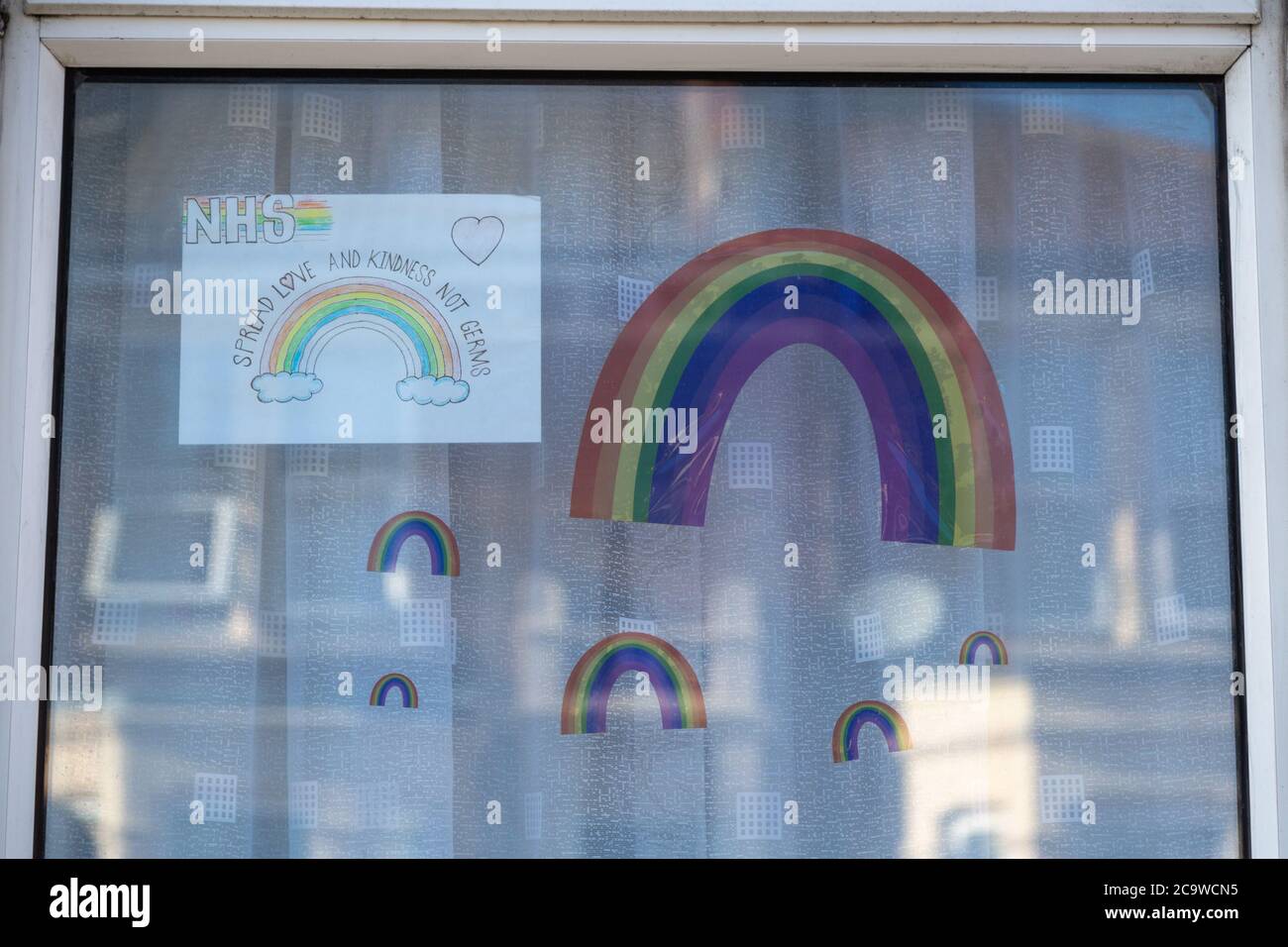 Arco iris dibujado por niños en las ventanas de su hogar durante la pandemia del Coronavirus o Covid-19 Foto de stock