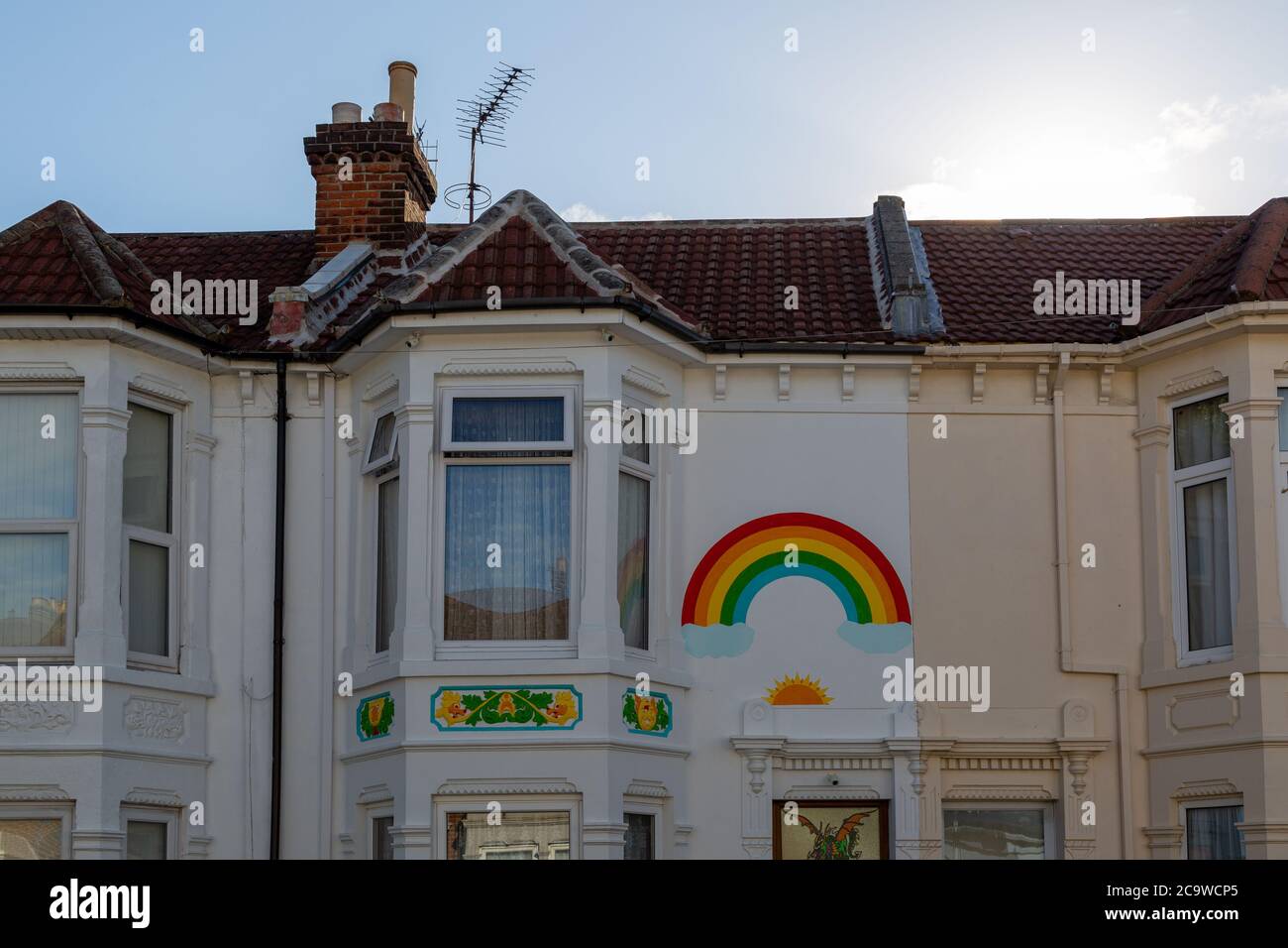 El frente de una casa inglesa pintada con un arco iris durante el brote de Covid-19 o coronavirus Foto de stock