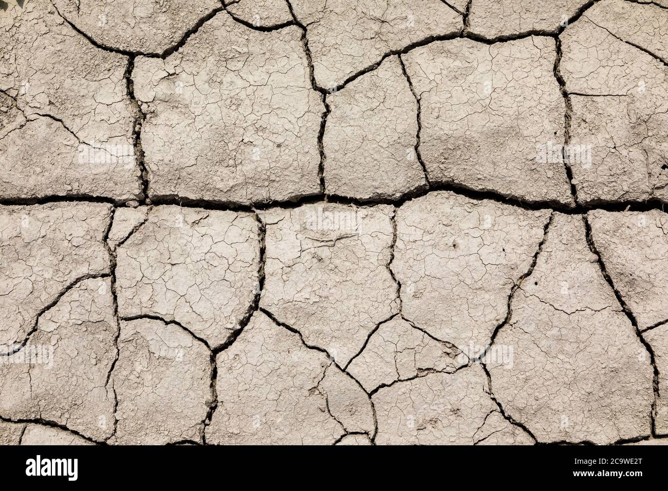 Tierra seca agrietada. A los campos les falta lluvia. Foto de stock