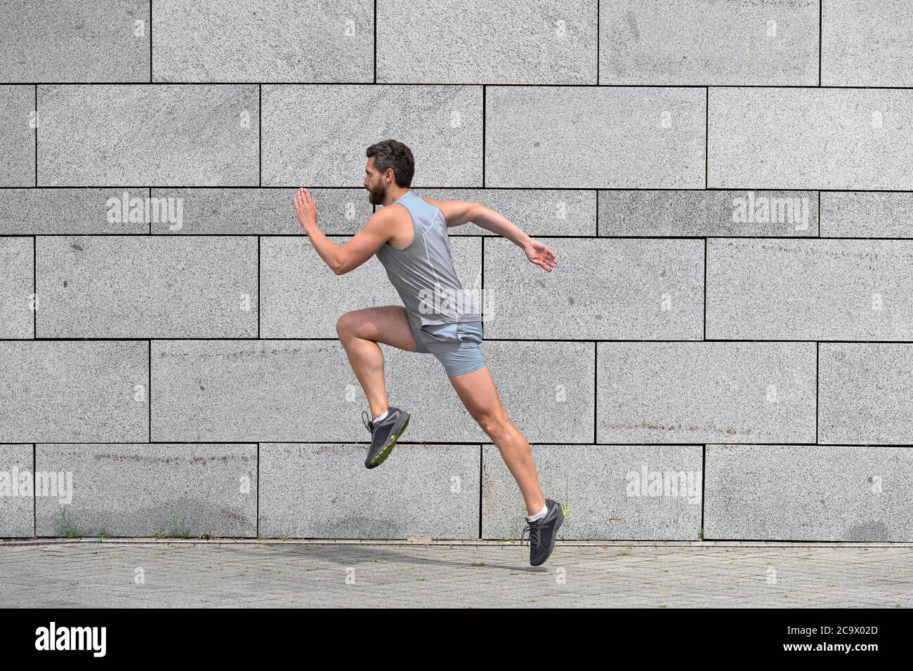 hombre corriendo éxito. éxito Lucha por la victoria. Hombre activo en la deportiva saltando mientras se ejercita al aire libre. Dé salto adelante Fotografía de stock - Alamy