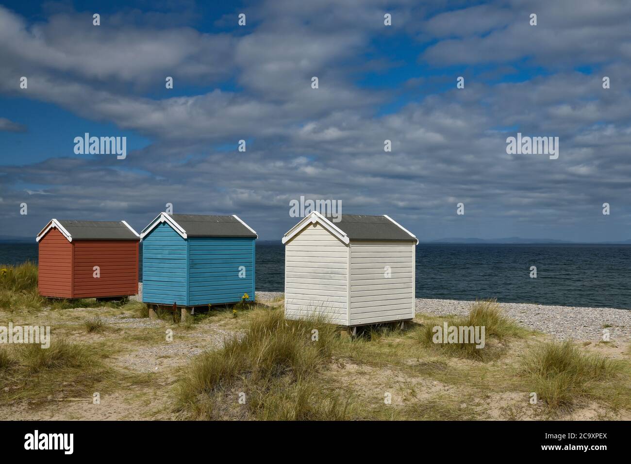 Coloridas cabañas de playa de color azul y blanco en Findhorn Beach, Moray Coast, Escocia Foto de stock