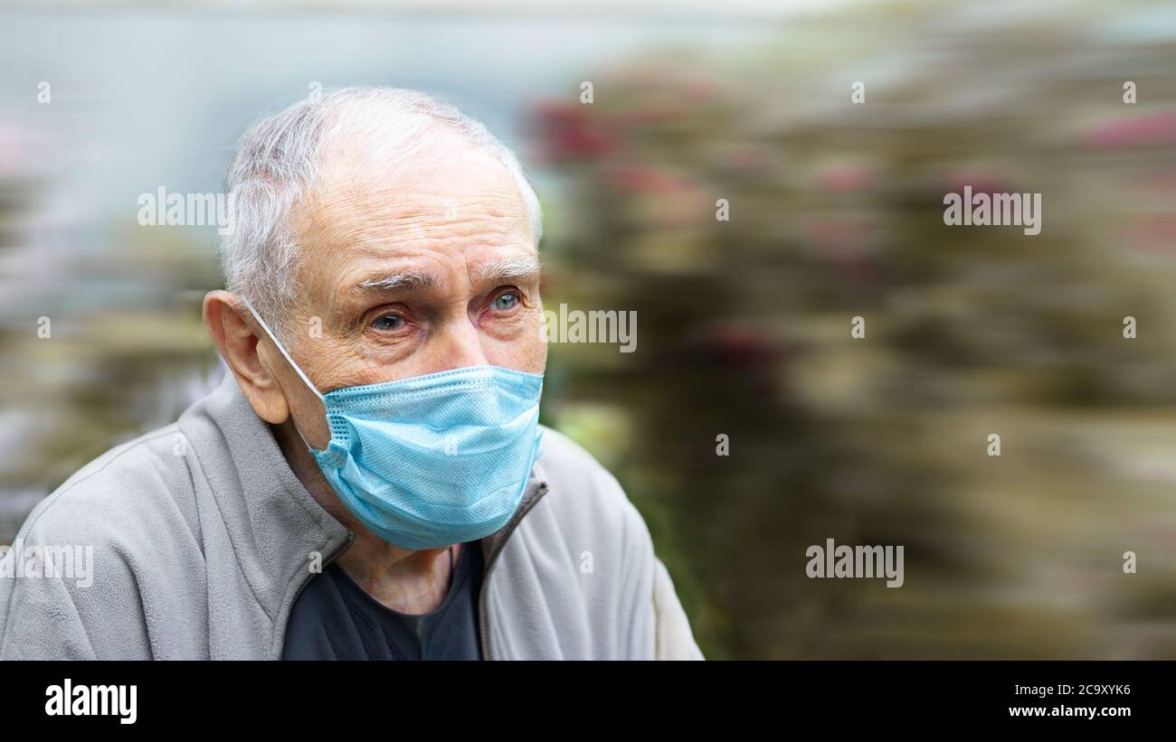 Hombre viejo en una máscara médica. Hombre viejo usa una máscara al aire libre para evitar infectarse con el virus Corvette-19. Prevención de enfermedades virales en el Foto de stock