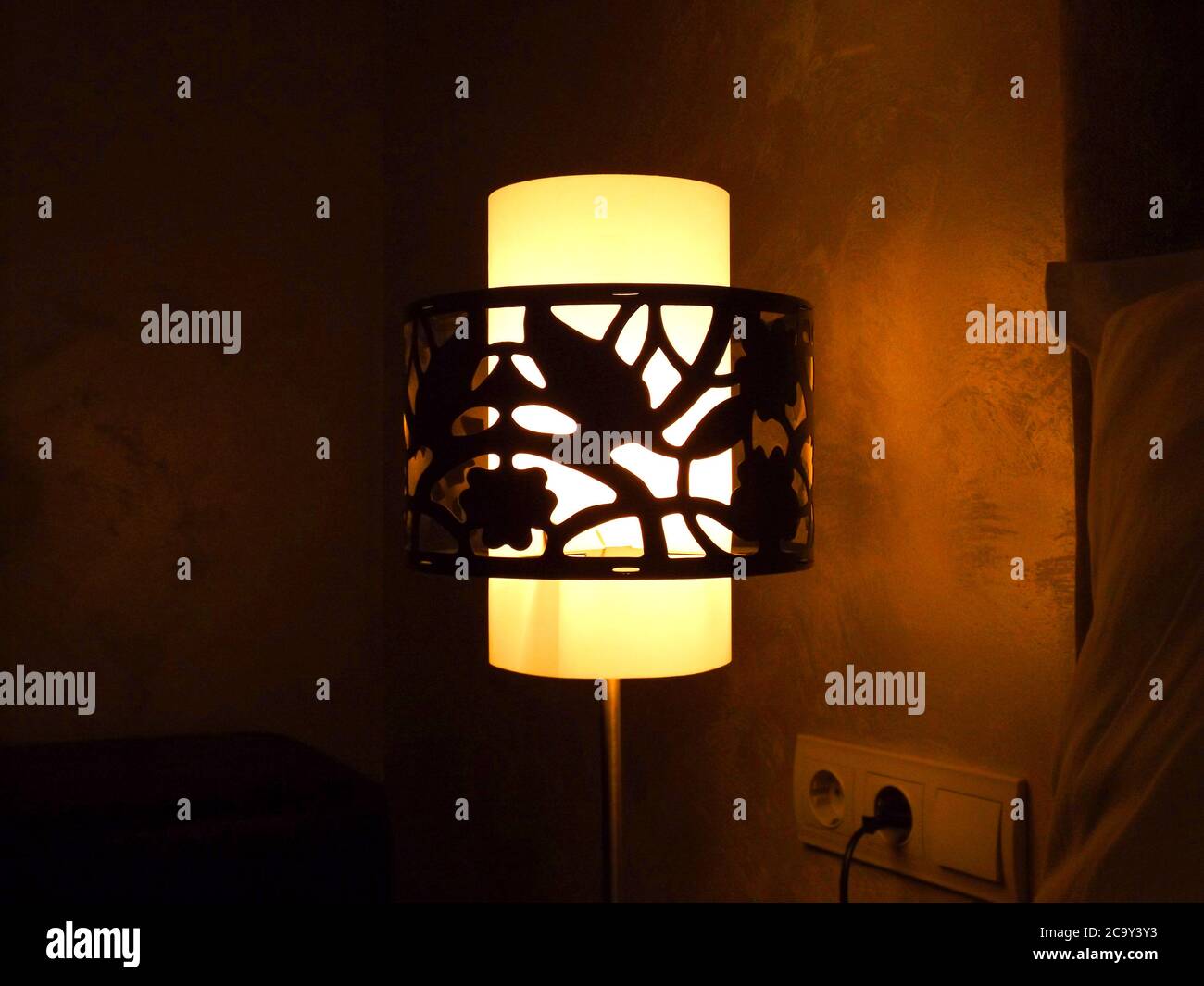 Imagen de una lámpara de noche que emite una luz suave en la habitación. Foto de stock