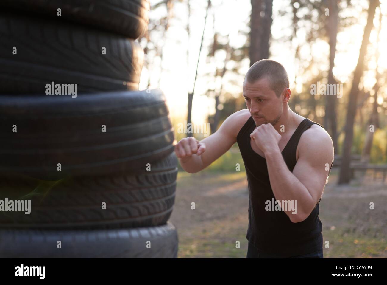Foto del Athletic hombre 20s en chándal negro y hacer boxeo punch durante  la mañana entrenando por la costa Fotografía de stock - Alamy