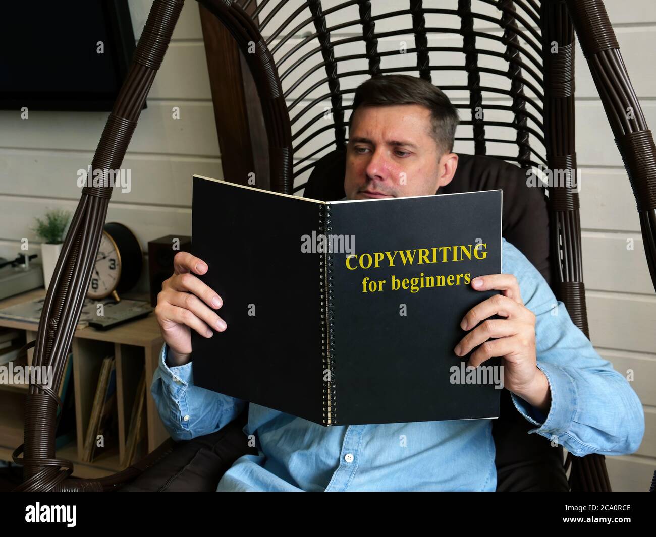 Redacción para principiantes. Un hombre está leyendo una guía en casa. Foto de stock