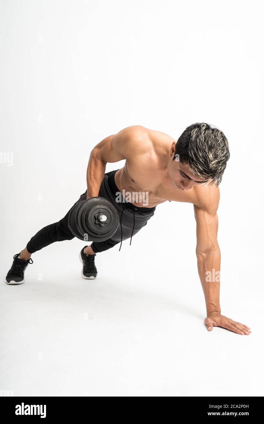 músculo hombre sin ropa hacer ejercicios de empuje con una mancuerna en una  mano sobre un fondo aislado Fotografía de stock - Alamy