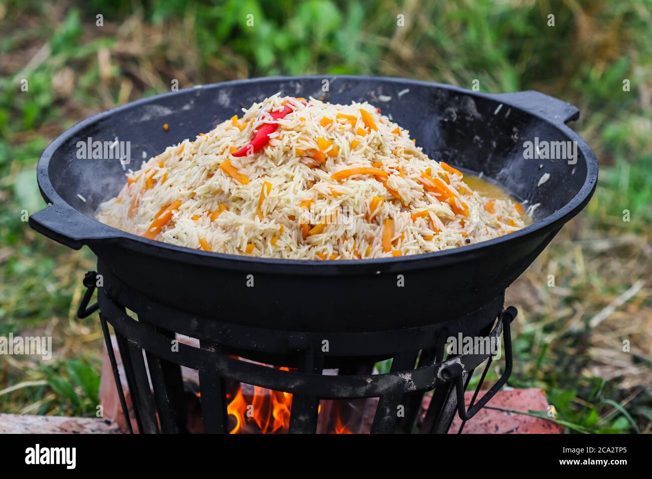 https://c8.alamy.com/compes/2ca2tp5/cocinar-arroz-pilaf-en-una-gran-olla-de-hierro-fundido-al-fuego-2ca2tp5.jpg