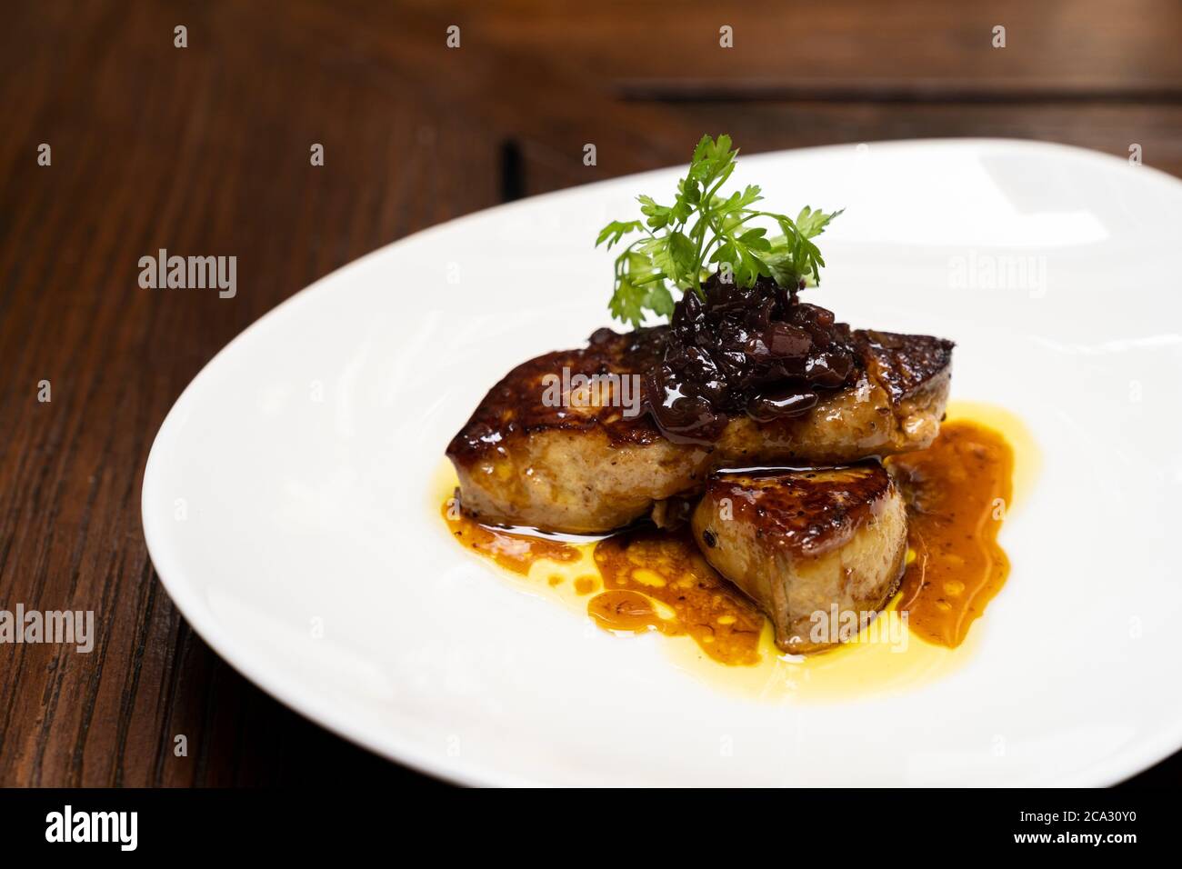 Foie gras a la parrilla, pato a la parrilla y pollo vivo de ganso, con  salsa de ciruela salada. Receta de cocina internacional gourmet que se  utiliza para la comida y bebida