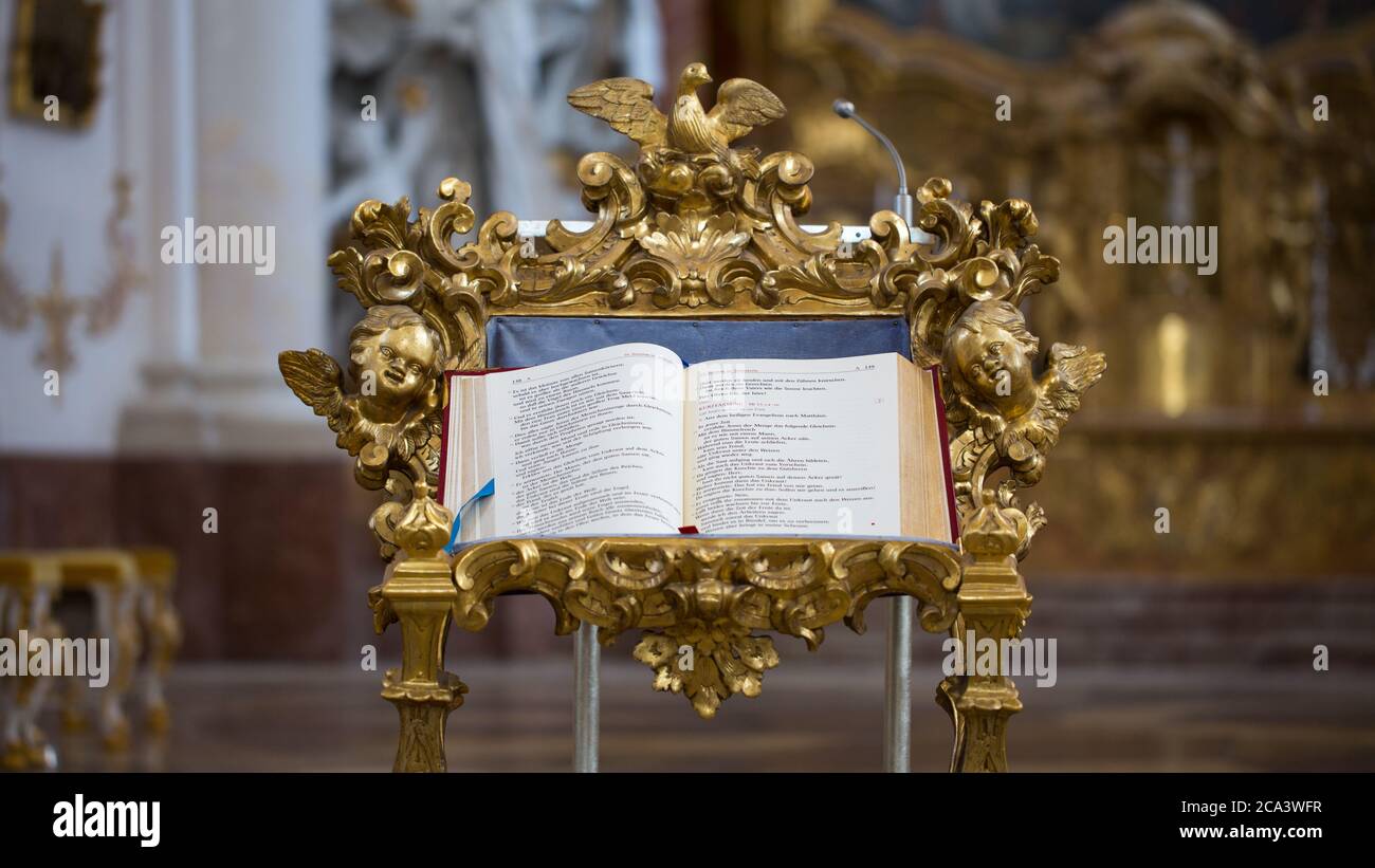 Primer plano de una biblia en una iglesia. Colocado en un atril de color dorado y ricamente ornamentado. Foto de stock