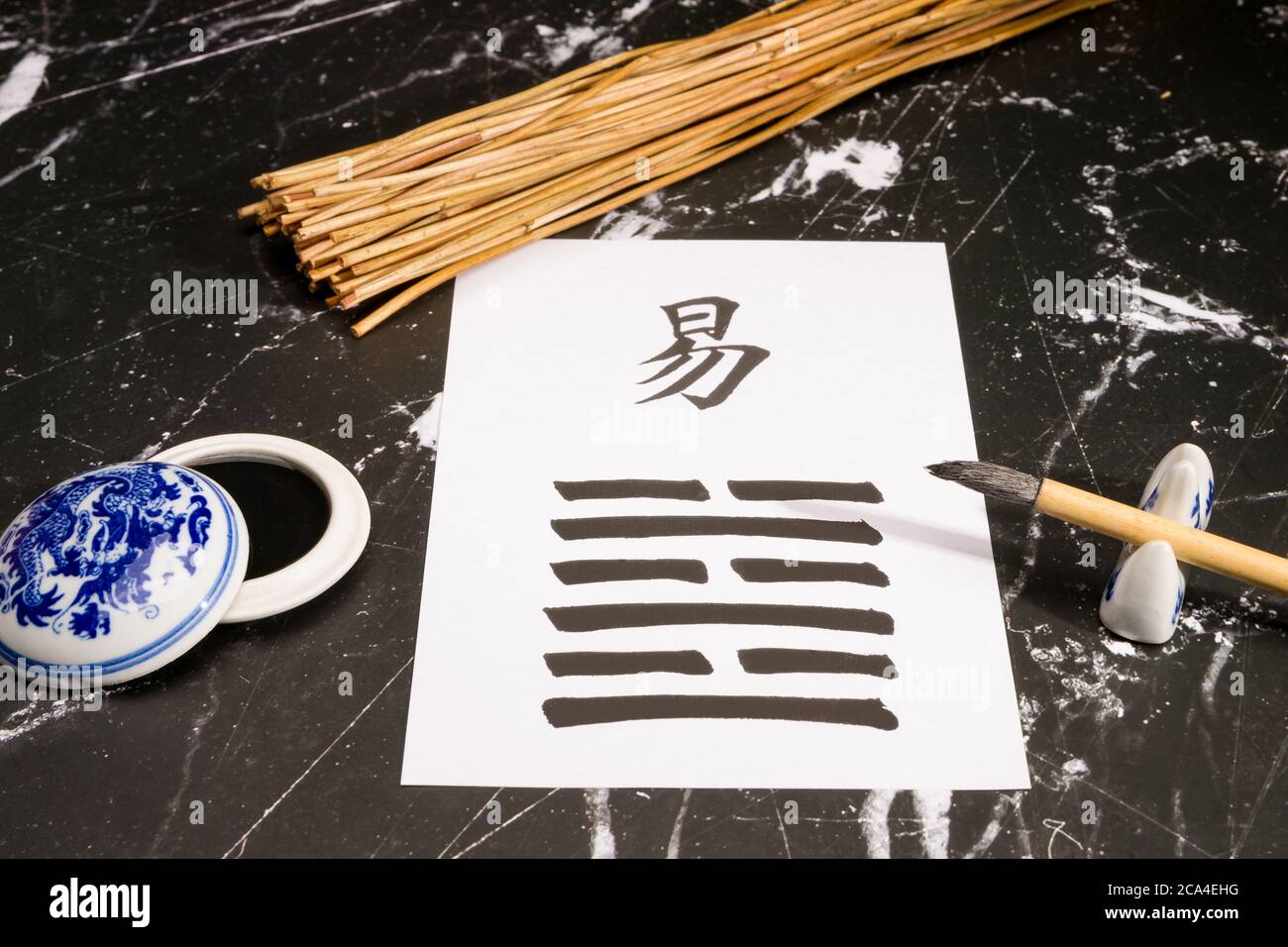 Primer plano de un arreglo I Ching con el hexagrama 63 (después de la  finalización/Chi Chi) escrito con un cepillo de tinta china en papel de  arroz. También hay Fotografía de stock -