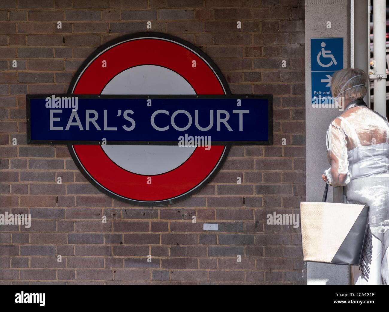 Piccadilly, Londres, Reino Unido. 4 de agosto de 2020. Los viajeros enmascarados esperan un tren subterráneo en la estación Earls Court, manteniendo las medidas de protección contra la pandemia de Coronavurus mientras viajan en el transporte de Londres. Crédito: Malcolm Park/Alamy Live News Foto de stock