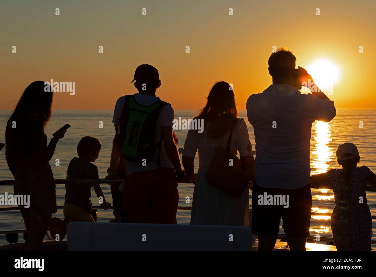 Gente viendo delfines al atardecer, tour con delfines, en Rovinj, Istria, Croacia Foto de stock