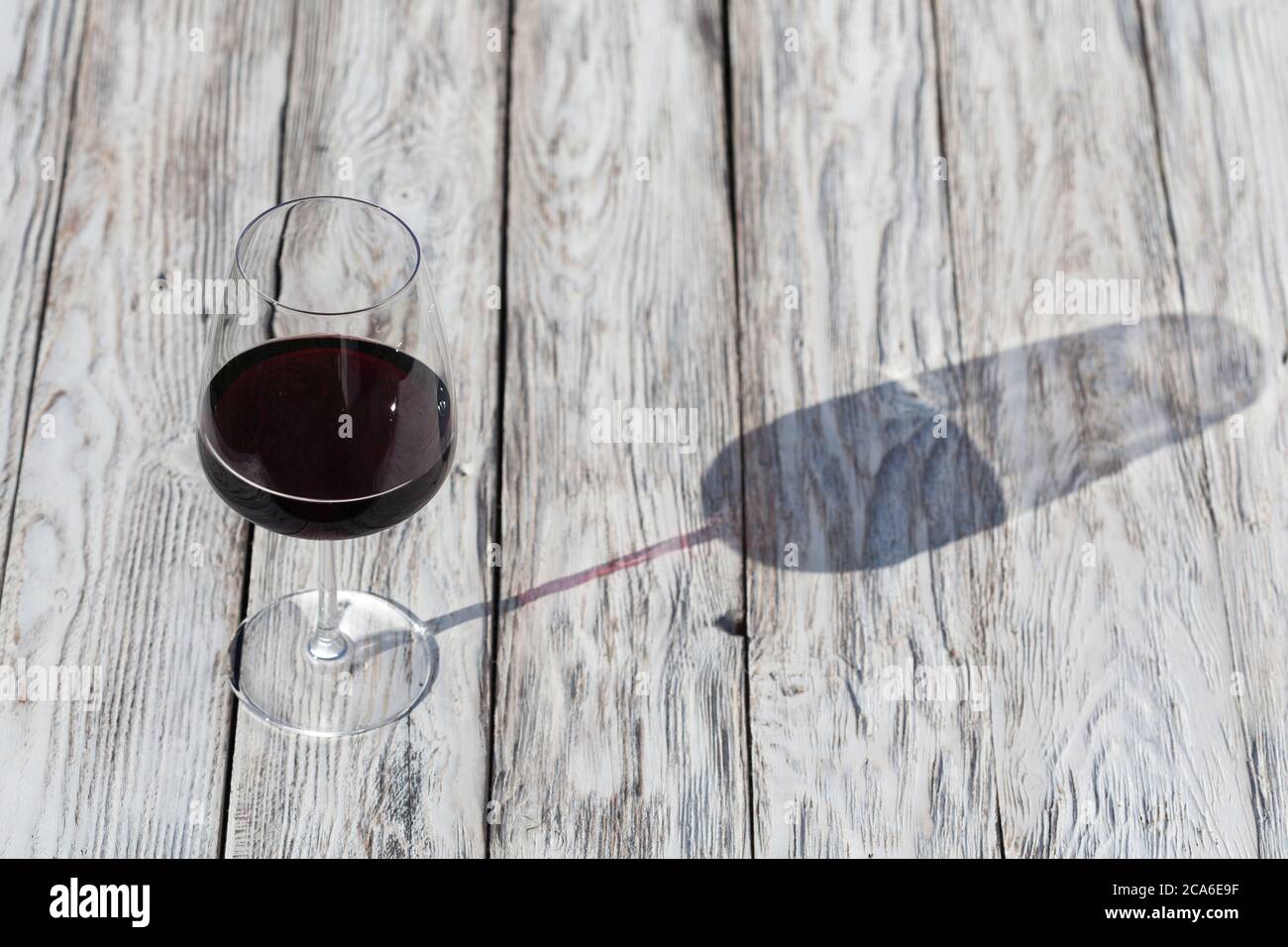 Copa de vino tinto sobre una mesa de madera de época Foto de stock