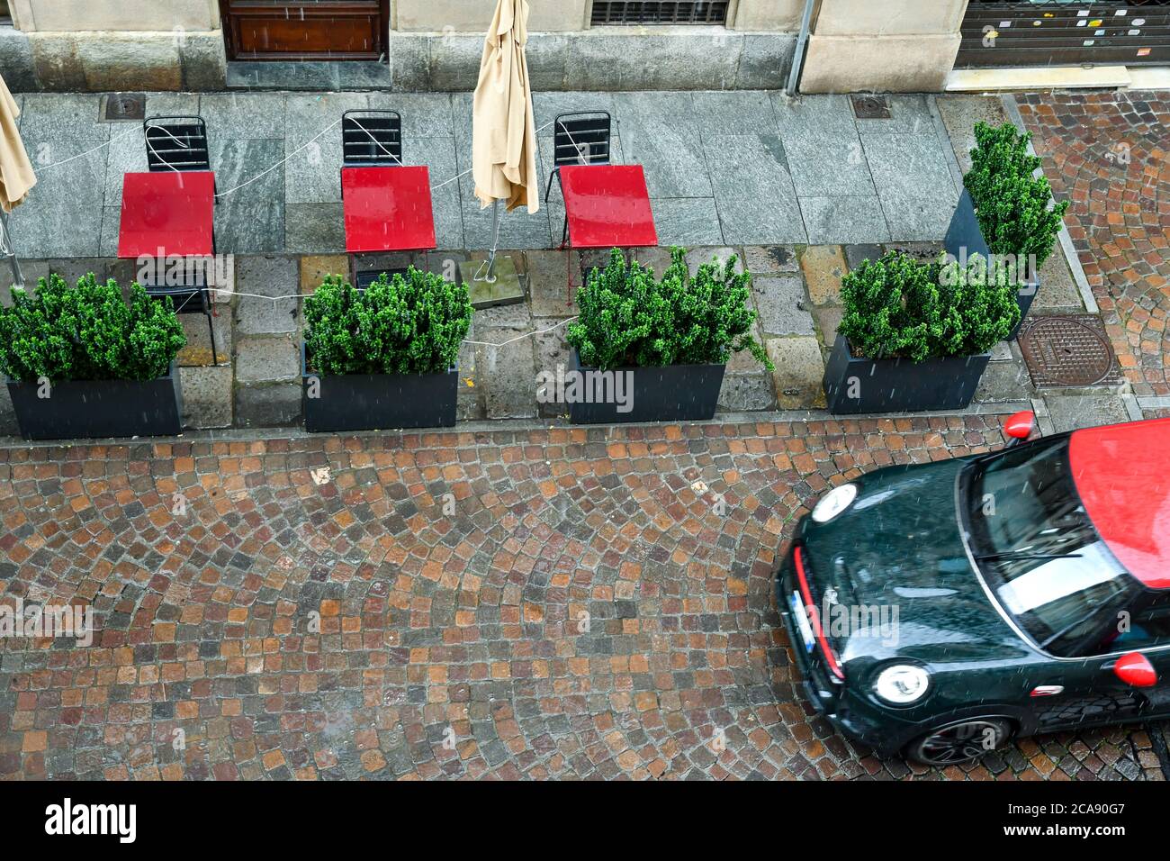Un mini BMW coche de la ciudad pasando en una calle del centro histórico en un día lluvioso, Turín, Piamonte, Italia Foto de stock