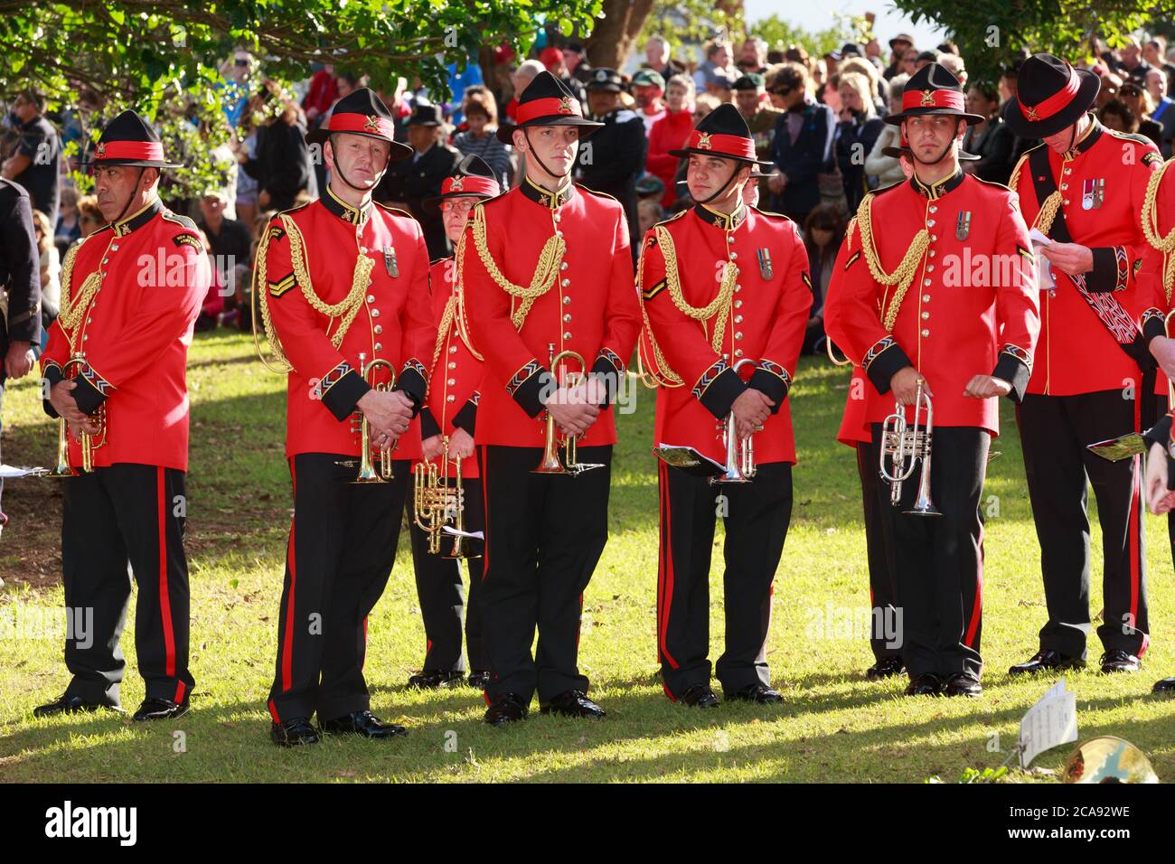 La sección de trompeta de la banda del Ejército de Nueva Zelanda con uniformes rojos ceremoniales en el 150 aniversario de la Batalla de la Puerta Pa. Tauranga, NZ, 4/29/2014 Foto de stock