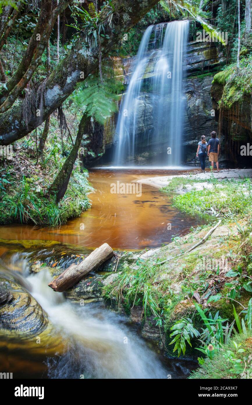 Backpackers disfrutando de una cascada prístina y la corriente de montaña en el corazón de la selva tropical sudamericana, Minas Gerais, Brasil, América del Sur Foto de stock