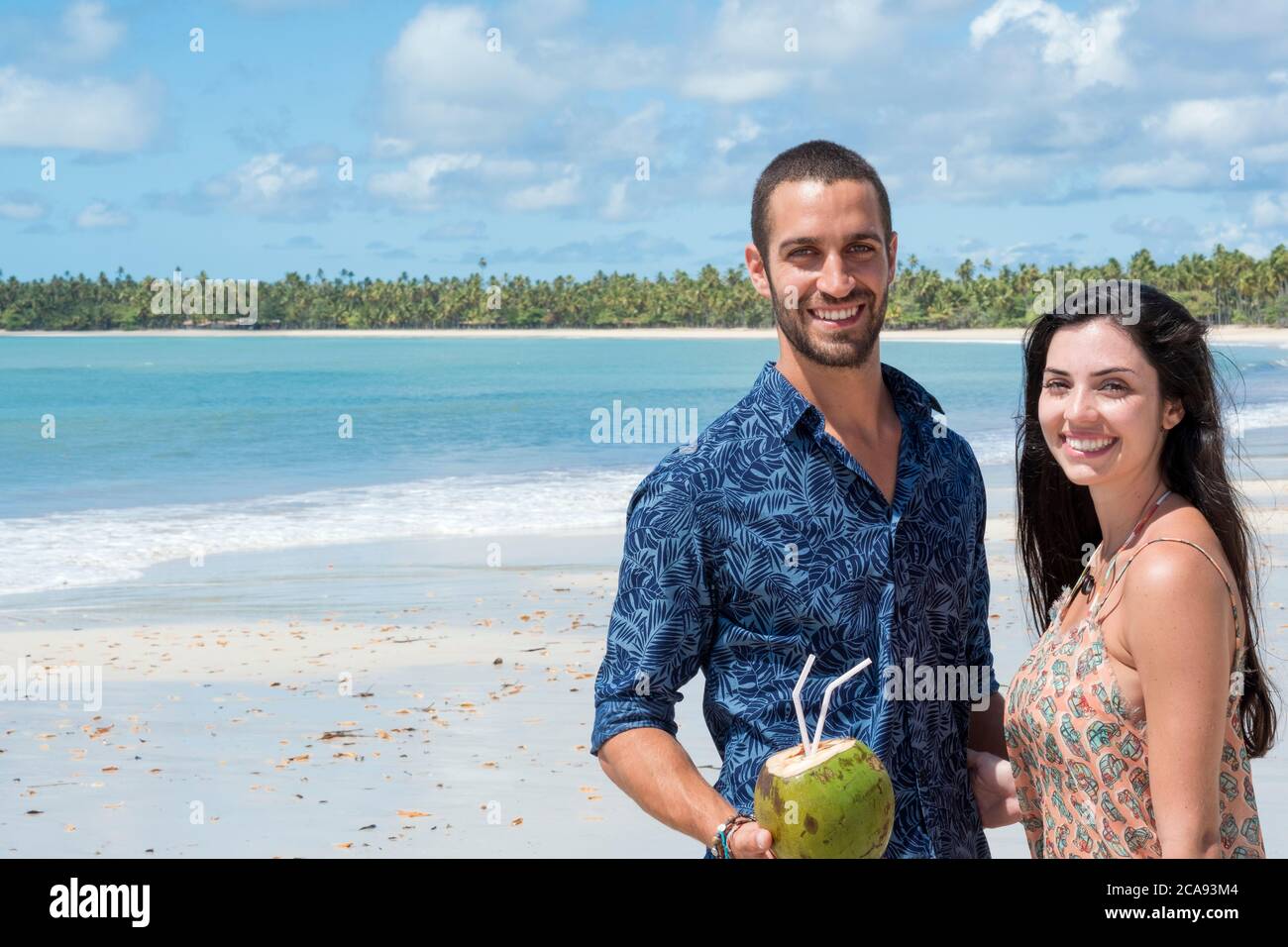 Una buena pareja hispana (latina) sonriendo y de pie juntos en una playa desierta, Brasil, Sudamérica Foto de stock