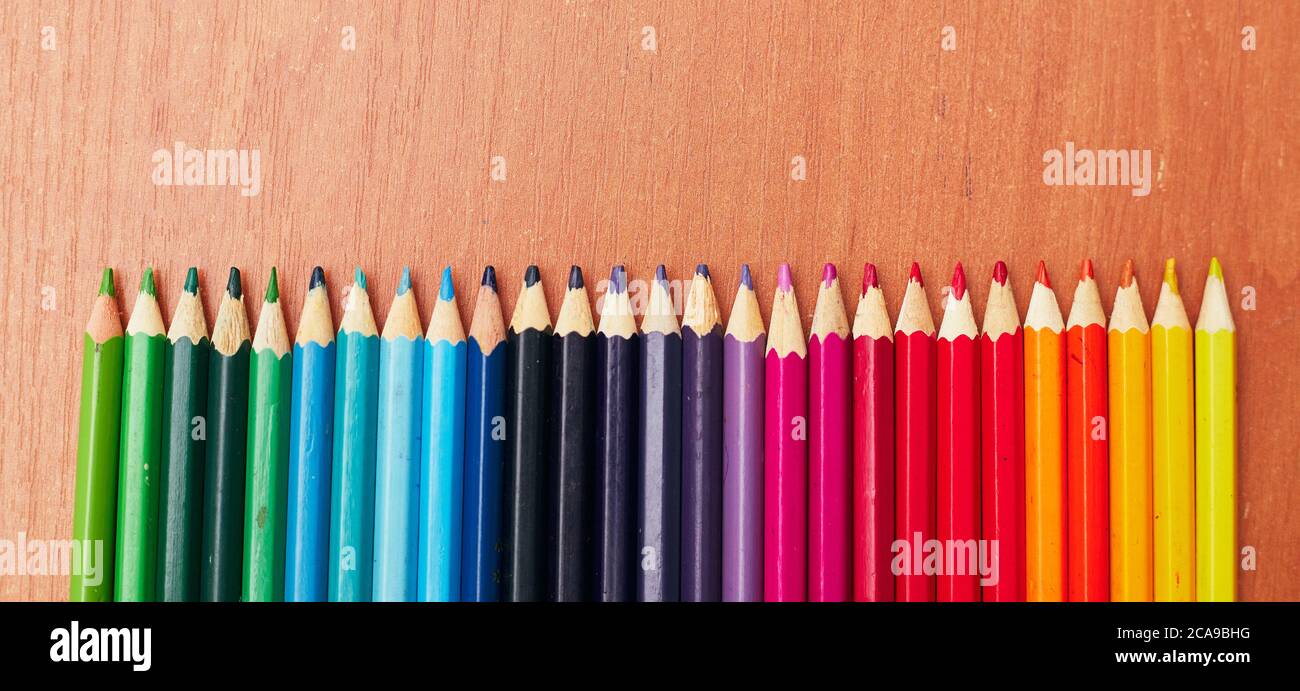 lápices de colores en una fila de acuerdo con la temperatura de color en la mesa, plana Foto de stock