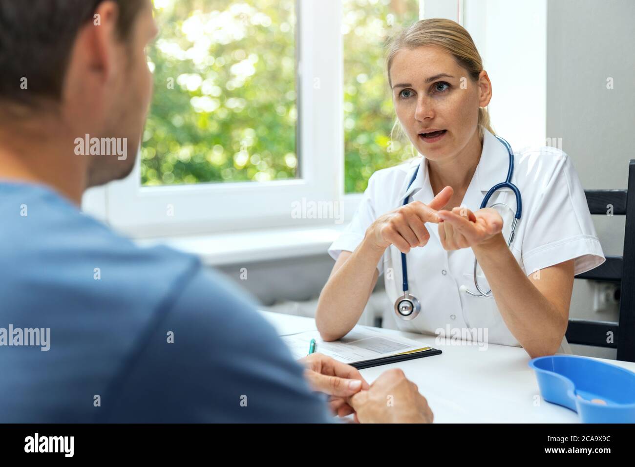 visita al médico. una joven mujer da consejo al paciente en el consultorio del hospital Foto de stock
