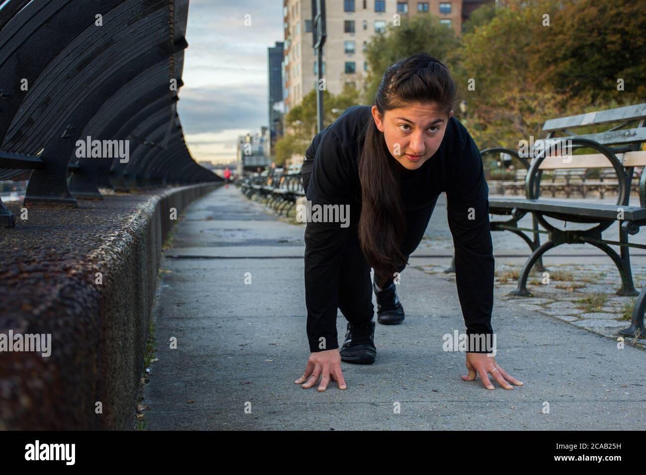Determinada mujer adulta joven dispuesta a correr fuera en las calles de la ciudad de Nueva York Foto de stock