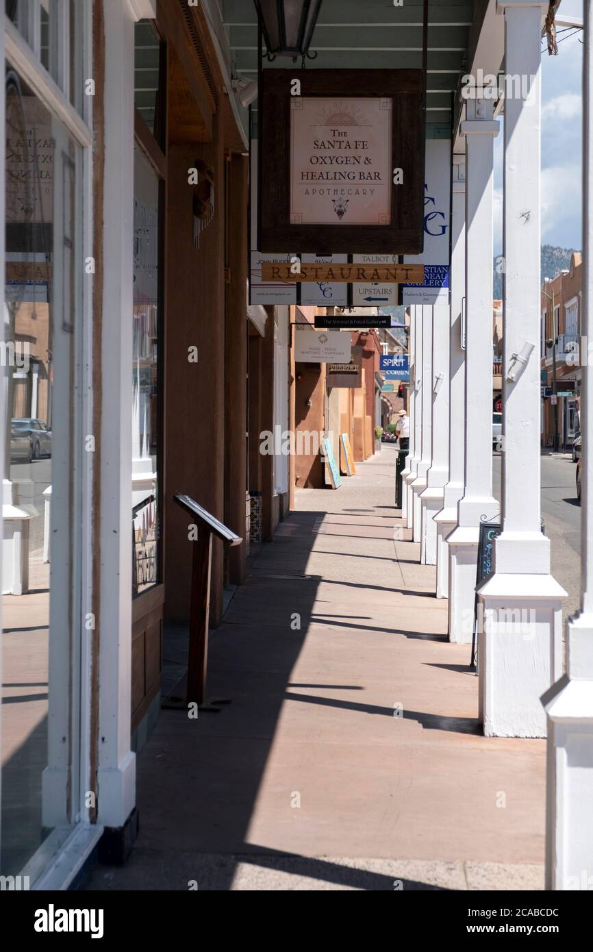 Acera cubierta frente a tiendas y restaurantes en la histórica Ciudad Vieja, Santa Fe, Nuevo México Foto de stock