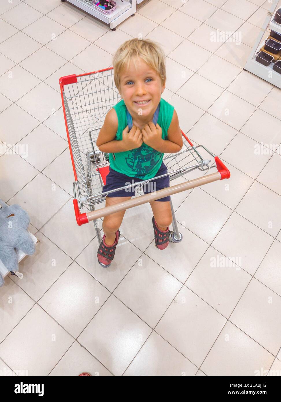 niño sentado en una cesta de compras en el supermercado pidiendo comprar un juguete  nuevo de compras con un concepto de niño Fotografía de stock - Alamy