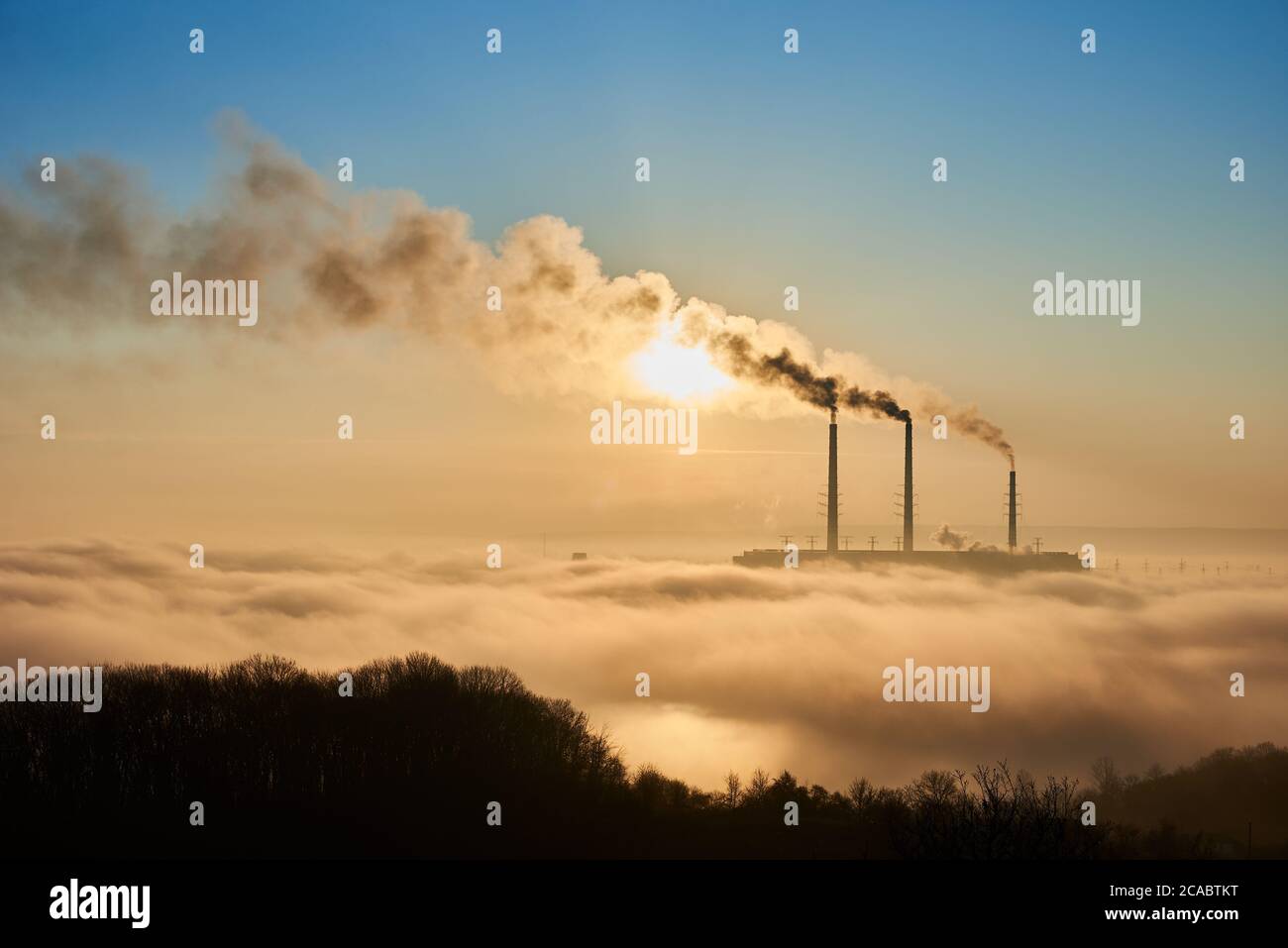 Imagen horizontal del área industrial al sol, tres tubos de humo de la central térmica Imagen horizontal del área industrial al sol, tres tubos de humo de la central térmica