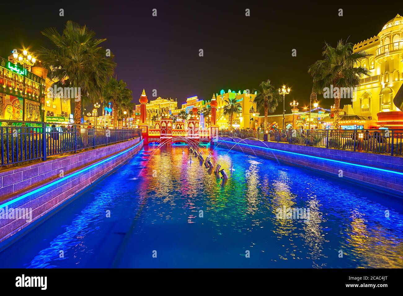 DUBAI, EAU - 5 DE MARZO de 2020: El canal de Global Village está decorado con luces brillantes a lo largo de las orillas, fuentes y puentes de pies escénicos Foto de stock