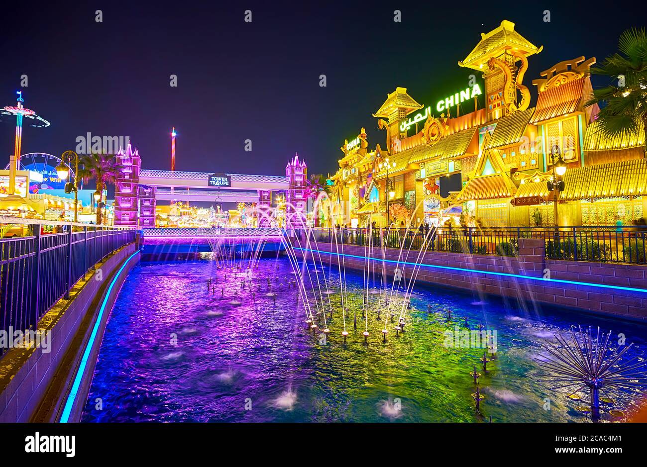 DUBAI, EAU - 5 DE MARZO de 2020: La noche en Global Village con una vista sobre las fuentes de baile escénico en el canal y pabellones iluminados en sus orillas, en Foto de stock
