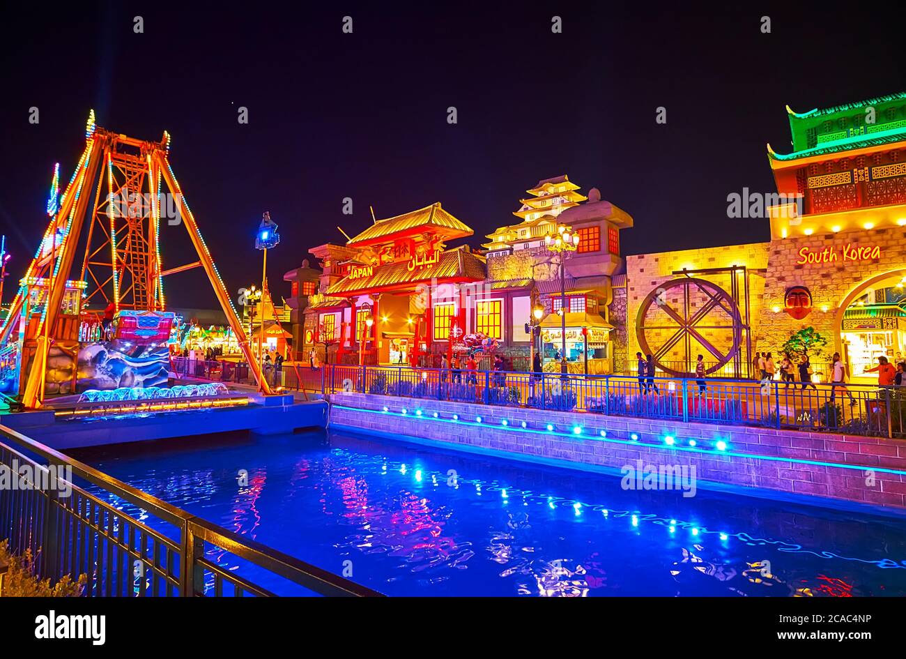 DUBAI, EAU - 5 DE MARZO de 2020: El canal brillantemente iluminado de la aldea Global Dubai con pabellones escénicos de comercio y exposición de Japón y Corea del Sur Foto de stock