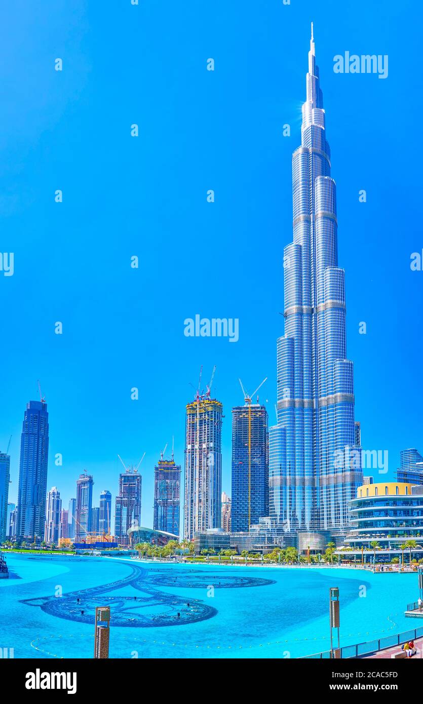 DUBAI, EAU - 3 DE MARZO de 2020: La vista escénica del magnífico edificio Burj Khalifa con los rascacielos circundantes y el lago artificial Burj en primer plano, on Foto de stock